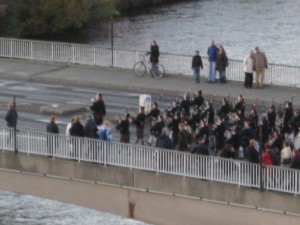 A parade marches across the bridge at Inverness to commemorate fallen soldiers