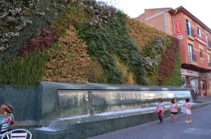A beautiful brick wall covered in different greenery, one of many fountains, and little girls!